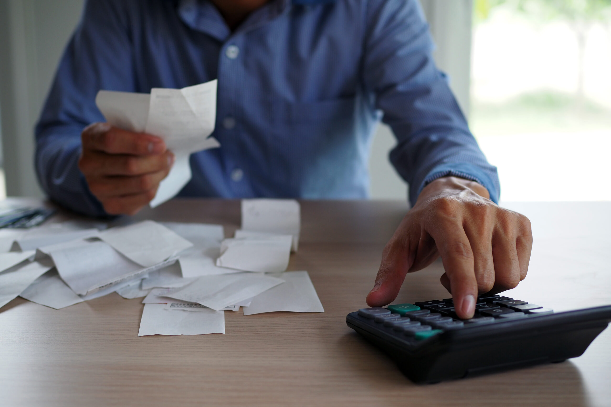 businessman-using-calculator-and-receipts-to-figure-his-merchant-cash-payments